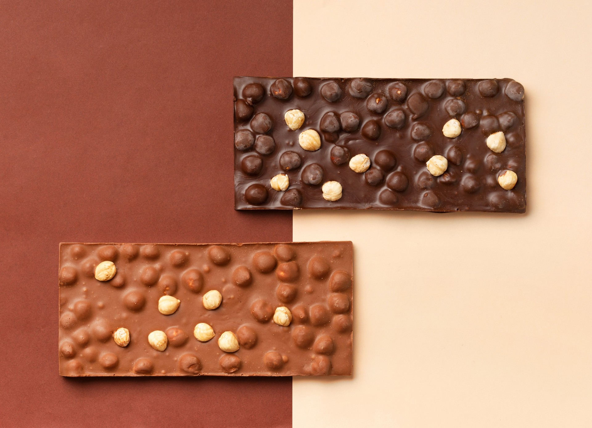 Two chocolate bars on a brown and beige background.